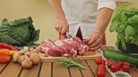 The hands of a chef with a knife in his hand cutting meat on the cutting board Stock-Footage 269034762