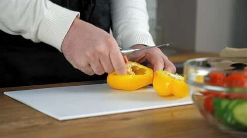 Hands chef man peeling fresh yellow bell pepper on cutting board in home kitchen Stock Footage 150020324