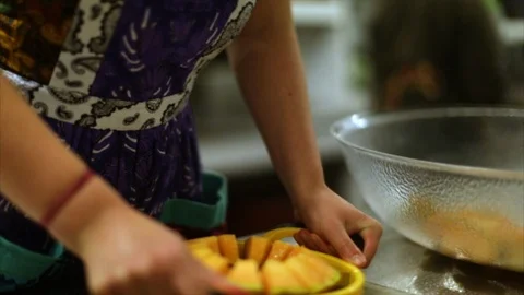 Hands of a chef slicing fruit into segments. Stock Footage 88405361
