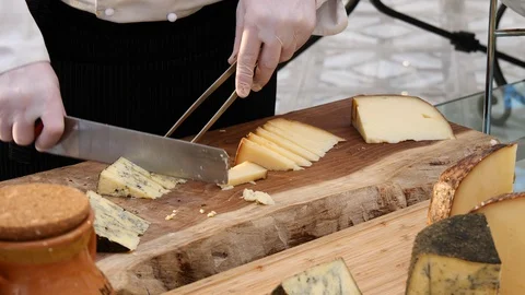 Hands of a Chef with white gloves cutting a delicious italian cheese Stock Footage 130113673