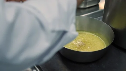 Hands chef in white uniform add spices to boiling butter in a metal frying pan Stock Footage 88674087