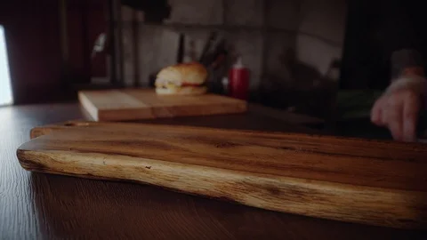 Hands of chief on commercial kitchen serves burgers on the wodden board - inside Vídeos de archivo 97796322