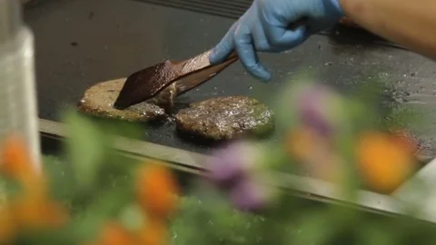 Hands of chief flipping meat for burger on grill. Stock Footage 79284667
