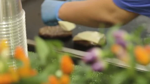 Hands of chief putting chees on meat for cheesburger on grill. Stock Footage 79284834
