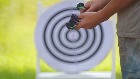 Hands of a child close-up on a background of darts toys. Stock Footage 114229815