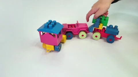 Hands of a child playing with a train made of a building blocks Stock Footage 283491023