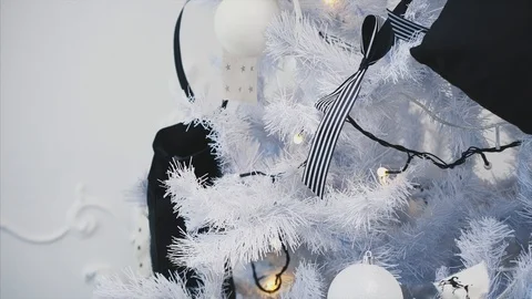 Hands of a child putting striped bow on a Christmas tree branch. Stock Footage 118995533