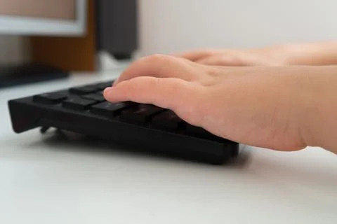 The hands of a child, typing on a keyboard Stock Photos