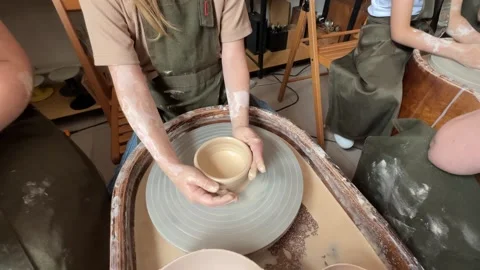 The hands of child work on a potter's wheel and make a pot from clay Stock Footage 277788389