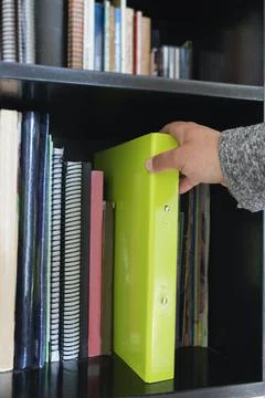 Hands choosing a book from the library Stock Photos