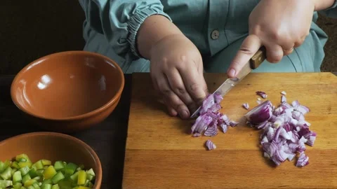 Hands chop red onions with a knife on a cutting board on the table and plac.. Stockbeeldmateriaal 330036249