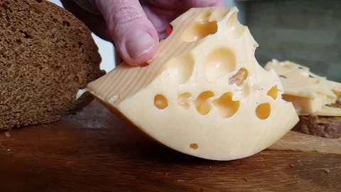Hands chop the Swiss cheese Stock Footage 88319614