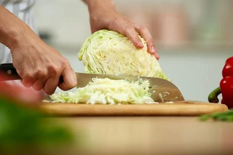 Hands chopping fresh cabbage on cutting board 写真素材