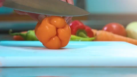 Hands chopping  fresh pepper on a cutting board with a knife Stock Footage 134468554
