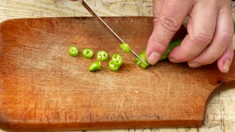 Hands chopping green fresh pepper on a cutting board Stock Footage 246077873