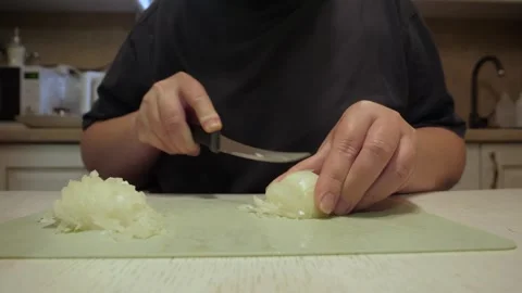 Hands chopping onion on kitchen board with steady knife motion Vidéo 342362083