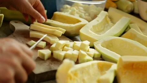 Hands chopping pumpkin slices on cutting board Stock Footage 81079859