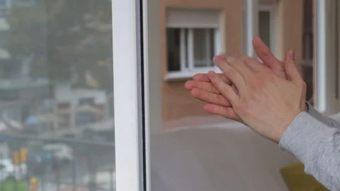 Hands clapping in window for coronavirus doctors and nurses who deserve a big Stock Footage 127995756