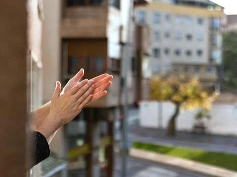Hands clapping in window for coronavirus doctors who deserve a big applause Stock Photos