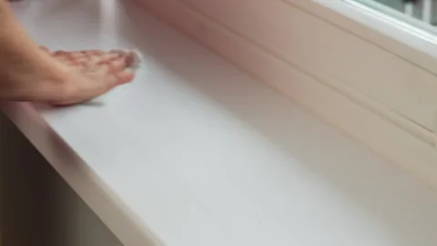 Hands clean window frame during home task in sunny room in afternoon with no vis Stock Footage 331742662