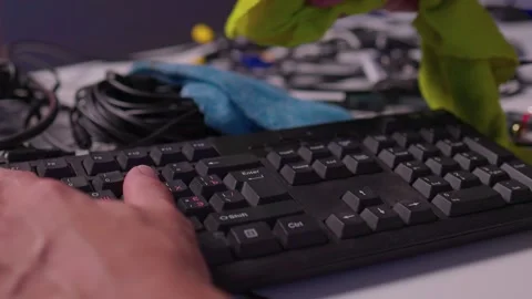 Hands cleaning computer keyboard with brush and microfiber cloth in close-up Stock Footage 347870277