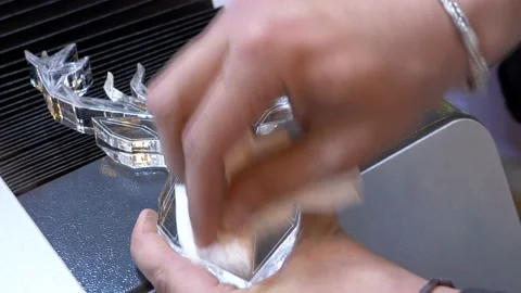 Hands cleaning a methacrylate figure after being cut by a laser Stock Footage 169076433