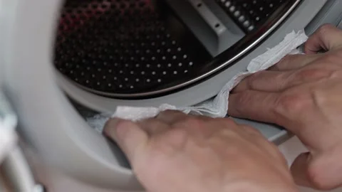 Hands cleaning moisture from the washing machine drum. Washing machine mainte 库存影片 160717994