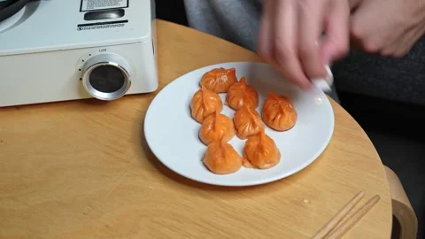 Hands Cleaning Plate Of Orange Dumplings Stock Footage 340849676