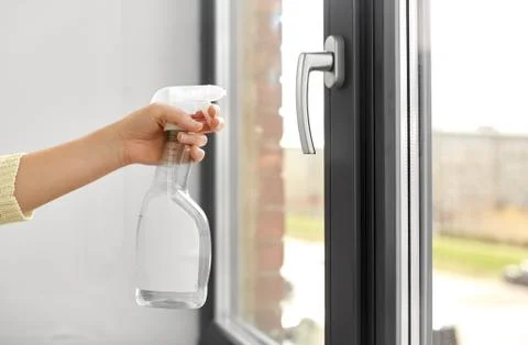 Hands cleaning window handle with detergent Photos
