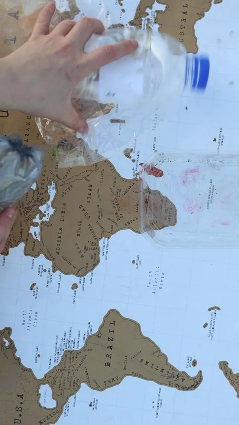Hands clear plastic waste from a world map Vidéo 337941588