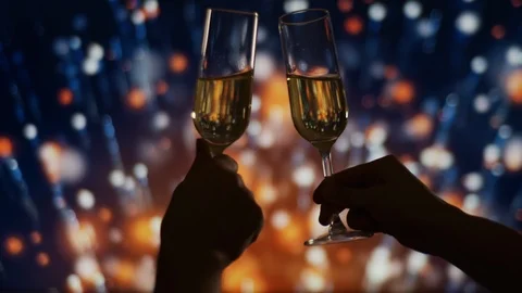 Hands Clinking with Two Glasses of Champagne with bubbles over fireworks Bokeh Vídeo Stock 121608440