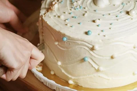 Hands close-up cuts a snow-white cake Stock Photos