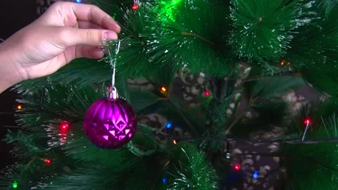 Hands close-up hang a bright red toy on the Christmas tree Stock Footage 145578649