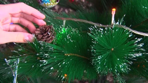 Hands close-up hang a toy in the form of a cone on the Christmas tree Stock Footage 145575767