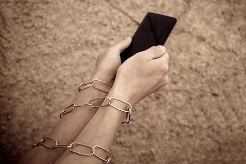 Hands close up hold phone held down by a chain Stock Photos