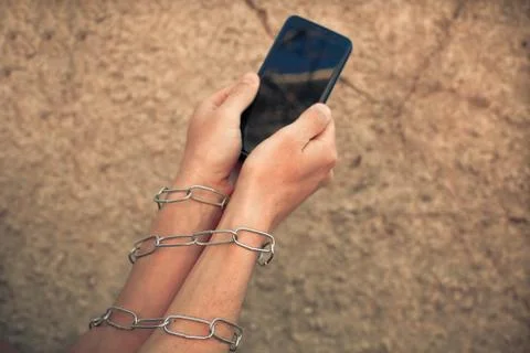 Hands close up hold phone held down by a chain Stock Photos