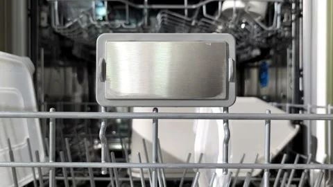 Hands close the lower dishwasher rack and open the upper rack to unload mug.. Stock Footage 338397732
