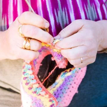 Hands close-up of an old lady knitting on knitting needles. Stock Photos