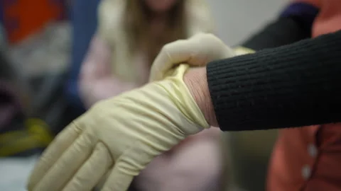 Hands close up. Paramedic putting on rubber sterile gloves to provide necessary Stock Footage 254182810