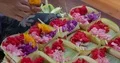 Hands close up preparing little baskets with Bali Hindu style flower decoration 4k or 4k+ Resolution