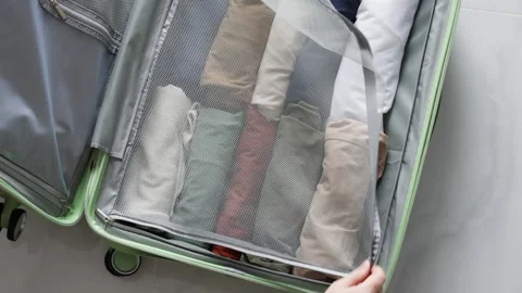 Hands close the suitcase lid filled with belongings. Stock Footage 311974983