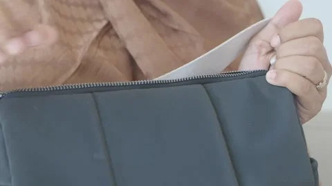 Hands close zipper on stylish bag in bright setting Stock Footage 312974144