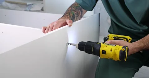 Hands closeup. Do-it-yourself. Man uses a work tool with a drill in a Stock Footage 276687223