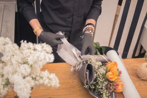 Hands closeup, florist working, making arranging flower bouquet Stock Photos