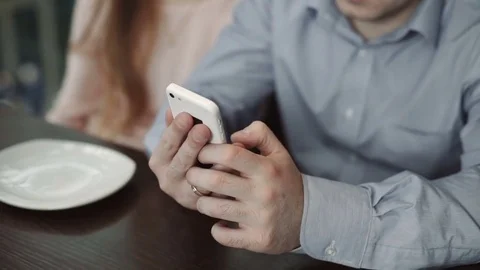 Hands closeup, young couple using smartphone at cafe Look at the display smiling Stock Footage 74813530