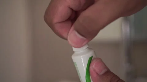 Hands closing a toothpaste cap in a bathroom. Vídeos de archivo 338428413