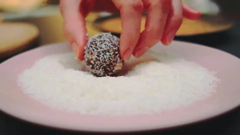 Hands Coating Date and Peanut Sweets with Coconut Powder Indoors Видео 342871749