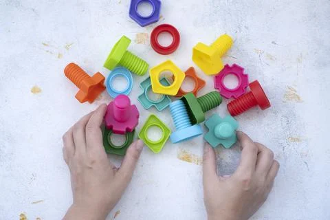 Hands collect educational constructor for children, nuts and bolts in the for Stock Photos