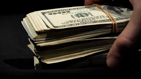 Hands collect a stack of dollars from the table close-up. Stock Footage 129786441