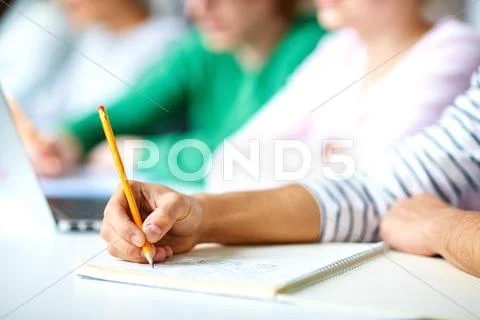 Hands of college students making notes at lecture Stock Photos